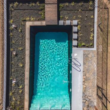 Aerial view of a modern rectangular swimming pool with surrounding landscape architecture.